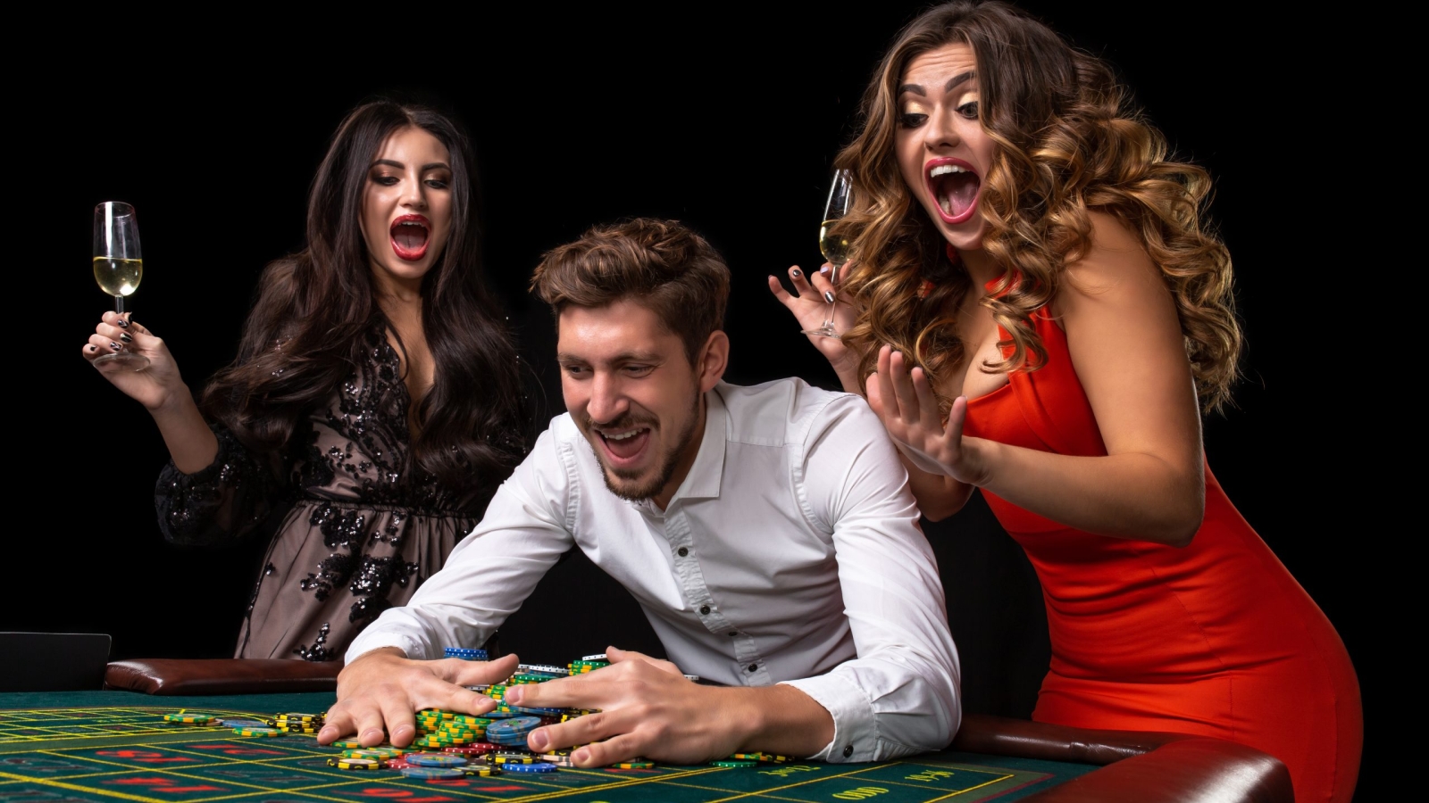 Adult group celebrating friend winning at roulette. Roulette table in a casino. Black background